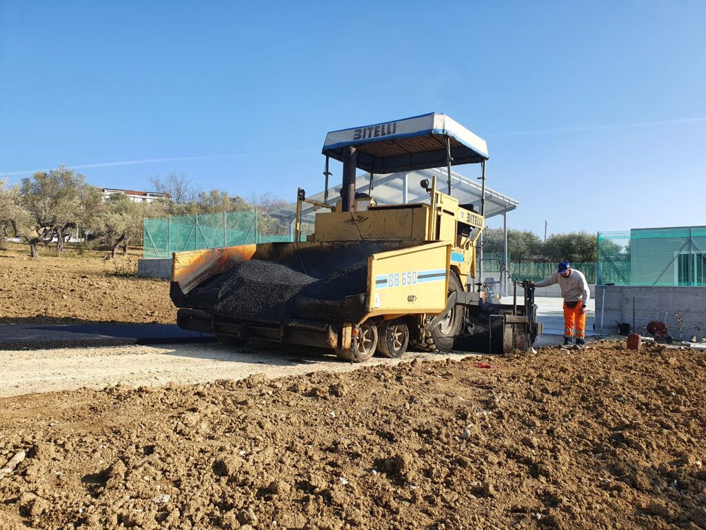 Vibrofinitrice carico di asfalto in azione